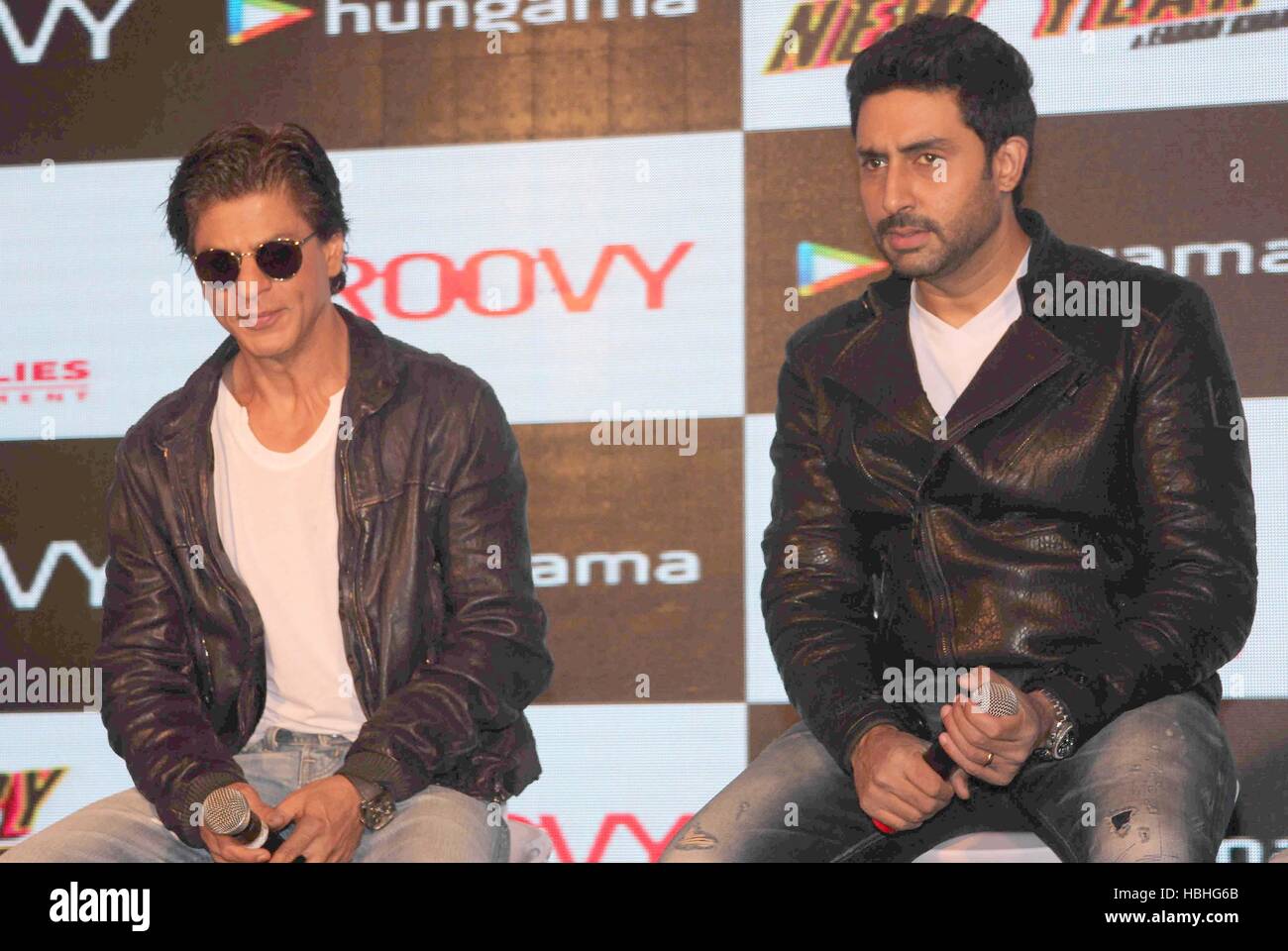 Abhishek Bachchan con l'attore Bollywood Shah Rukh Khan, maglietta bianca, giacca nera, occhiali di protezione, al film Happy New Year evento a Mumbai, India Foto Stock