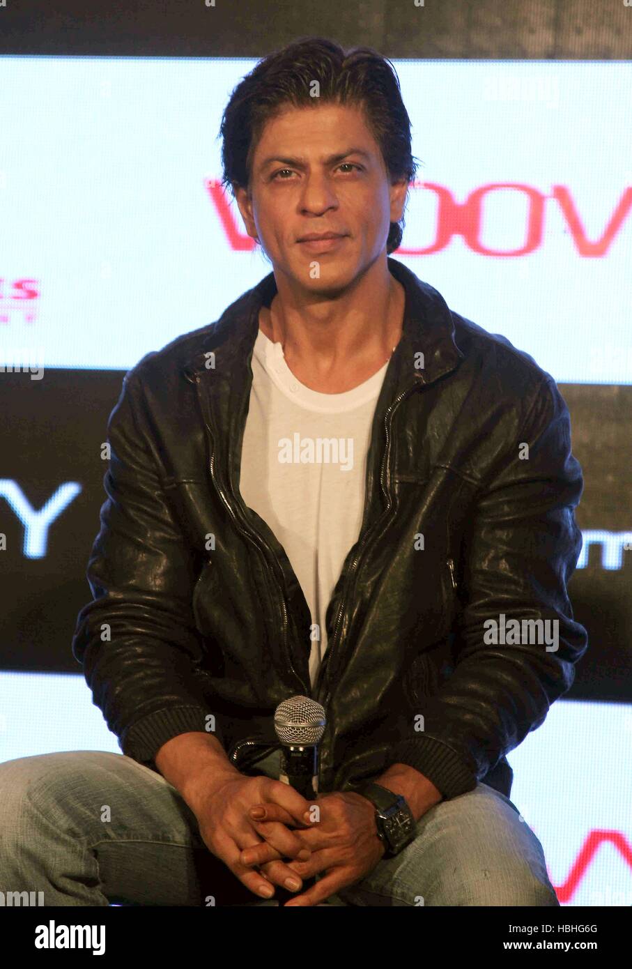 Attore Bollywood Shah Rukh Khan ritratto, camicia bianca, giacca nera, microfono in mano, al film felice anno nuovo evento a Mumbai, India Foto Stock