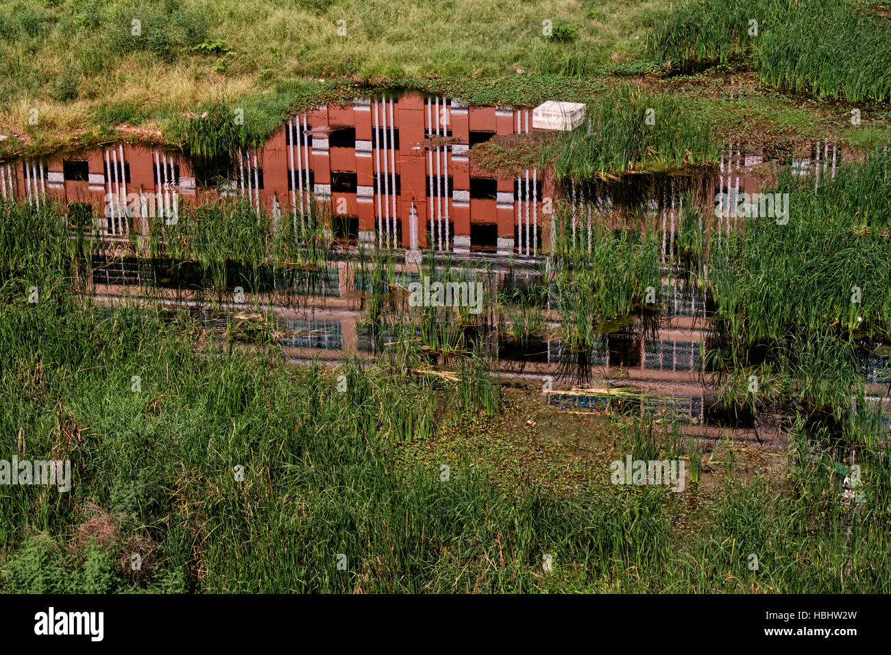 Un riflesso di un condominio in un spazio abandonded a Bangkok, in Thailandia Foto Stock