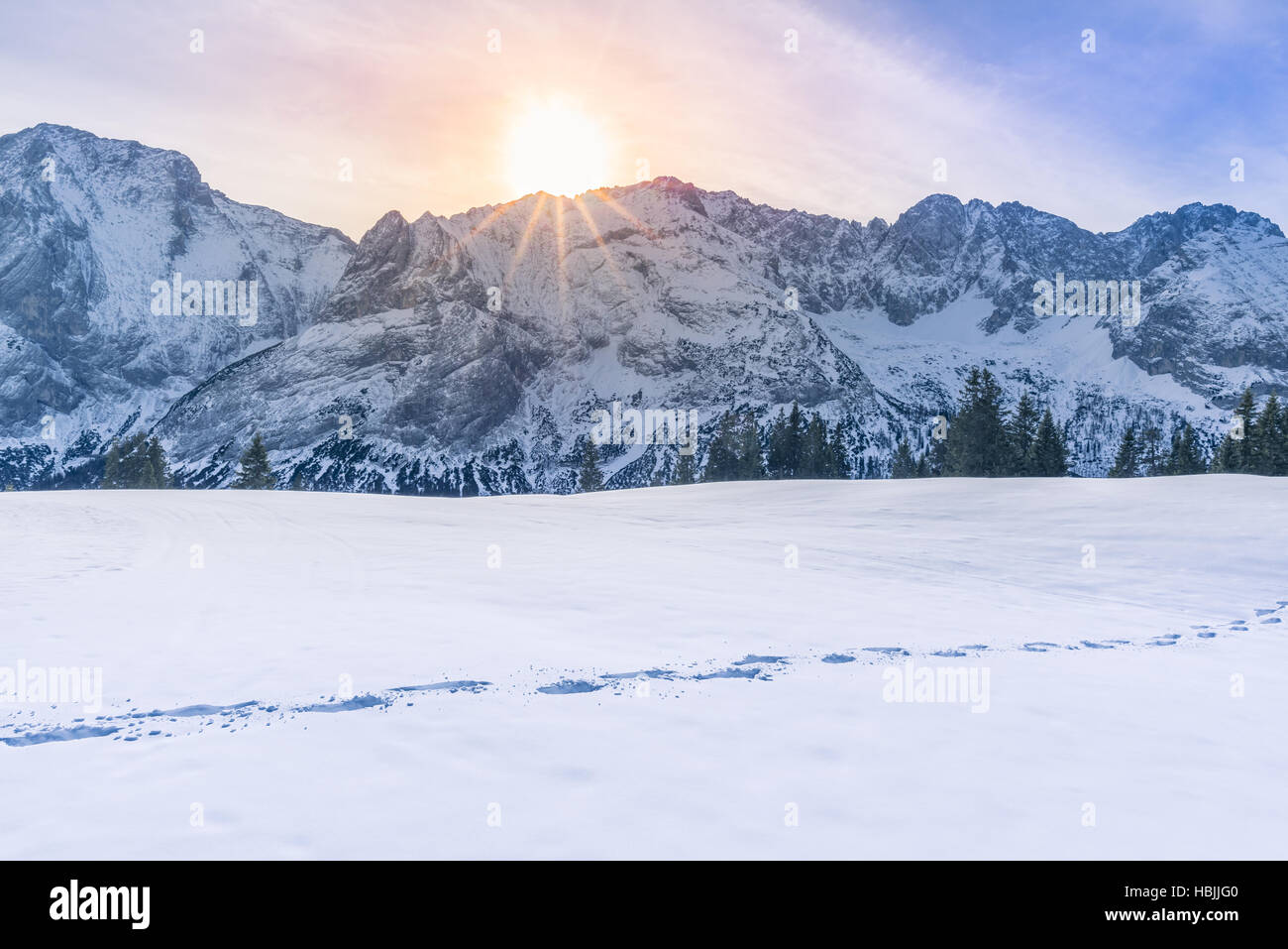 Sole che splende su picchi di montagna e neve Foto Stock