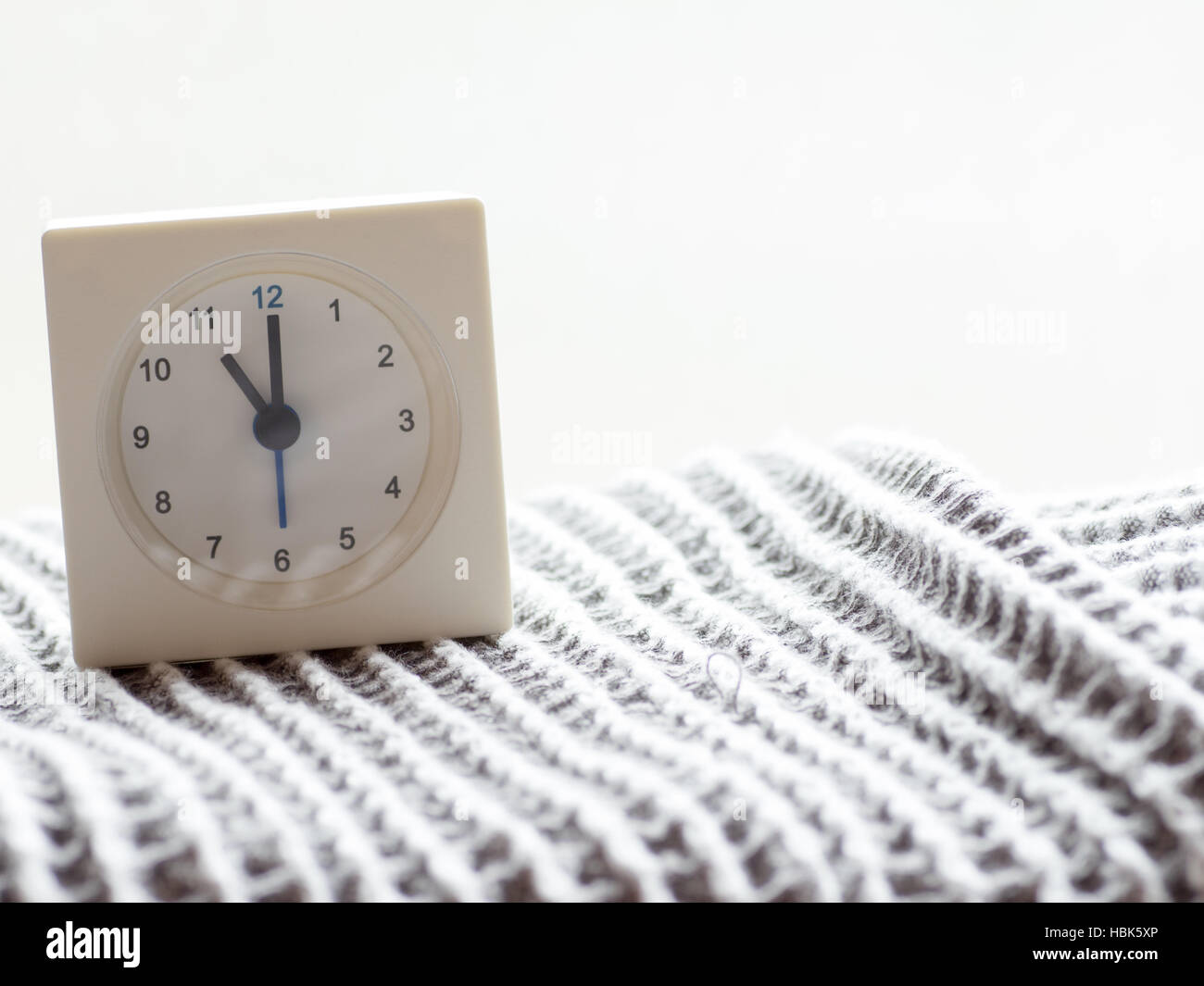 La serie di un semplice bianco orologio analogico sulla coperta che raffigura il tempo al mattino 13/15 Foto Stock