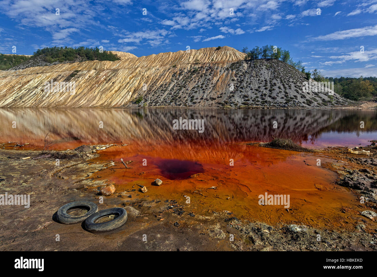 Rosso lago artificiale e le colline come un risultato di estrazione e  produzione di rame Foto stock - Alamy