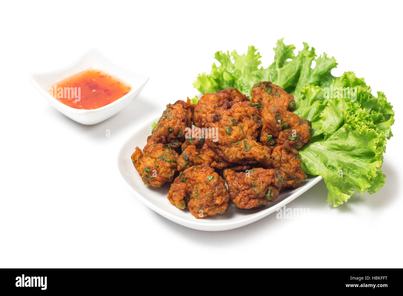 Thai pesce fritto torta (Tod Mun Pla) o di gamberi sfera crocchette di servire con salsa rossa tailandese tradizionale ricetta alimentare isolati su sfondo bianco Foto Stock