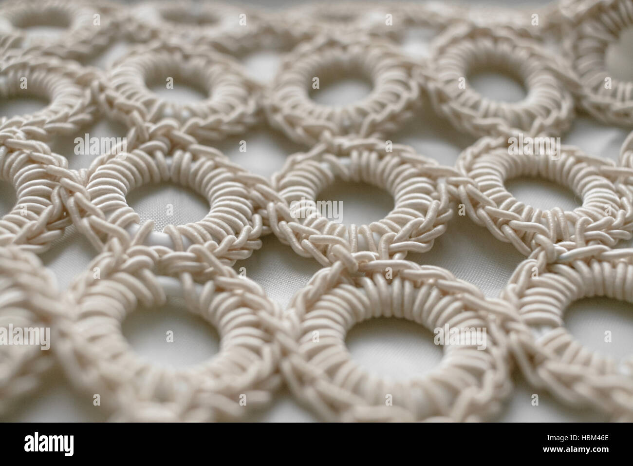 Close-up di corda intrecciata anelli di pattern su bianco textured background. messa a fuoco selettiva. Foto Stock