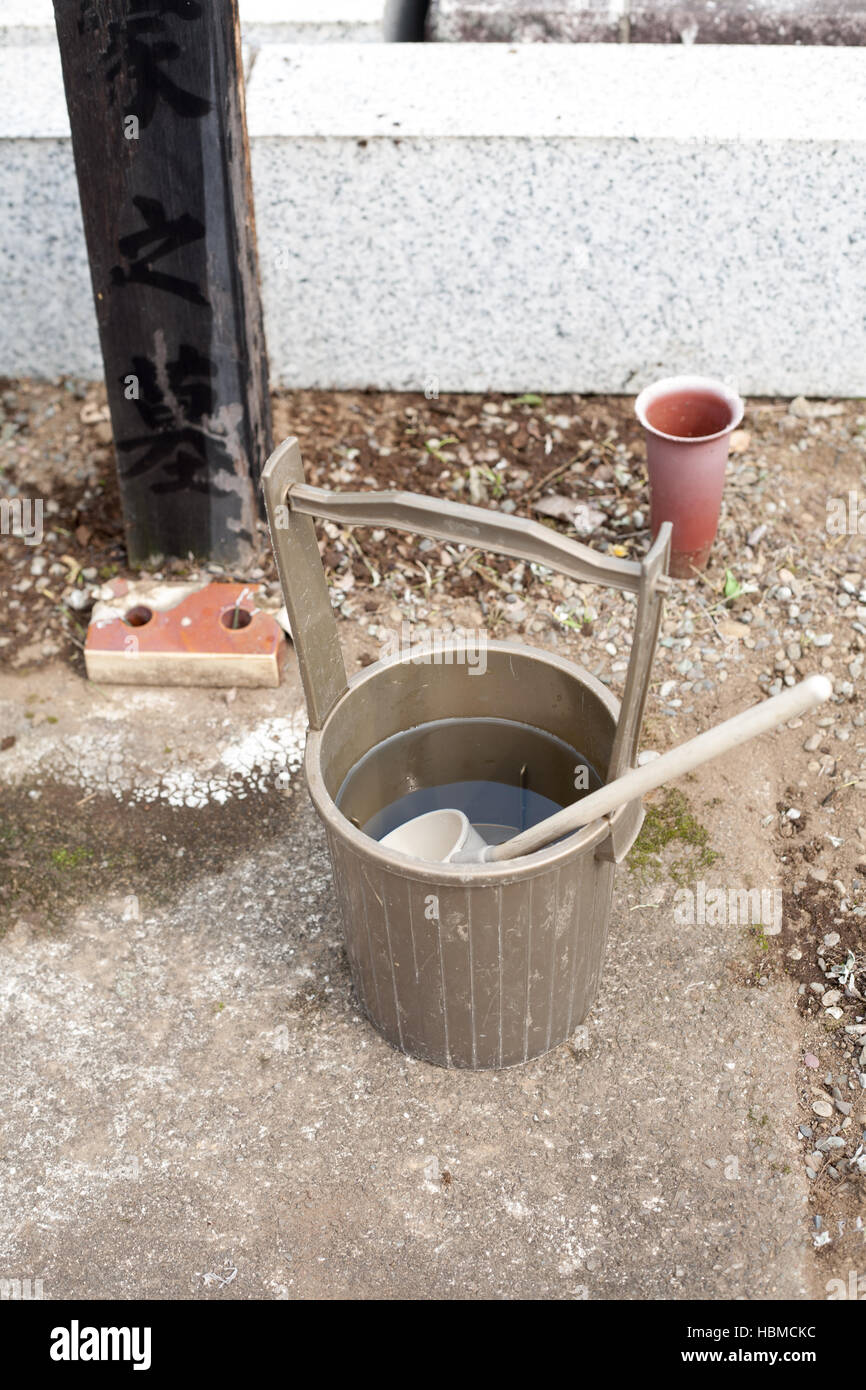 Religiosi giapponesi e benna siviera per purificare al vecchio cantiere grave Foto Stock