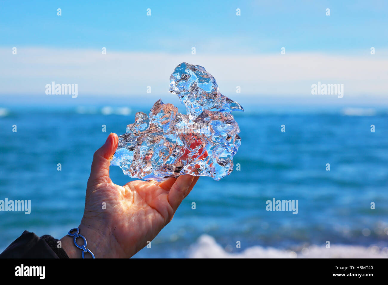 Trasparente pezzo di ghiaccio in mano femmina Foto Stock