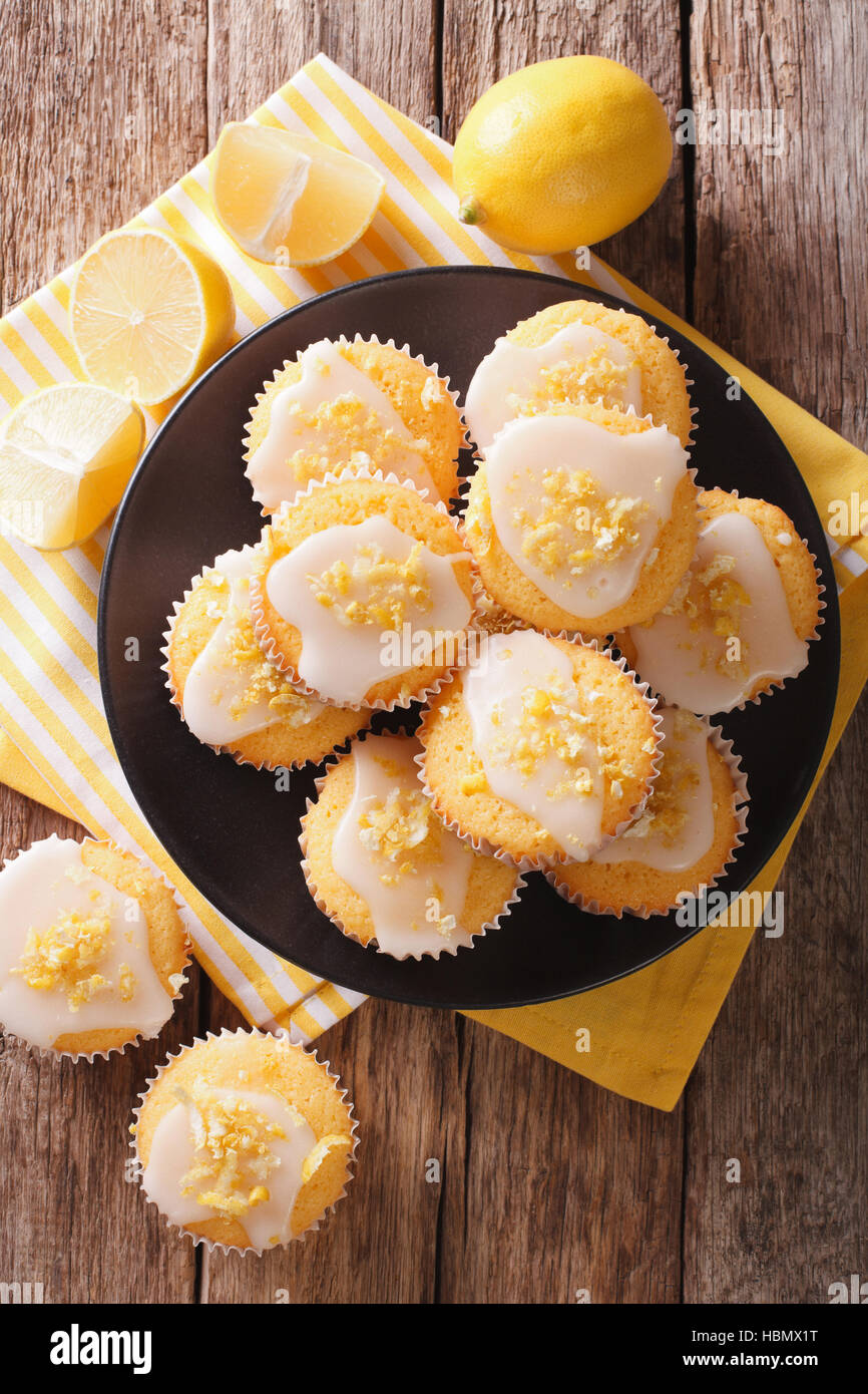 Dolce limone muffin con la scorza e zucchero a velo close-up su una piastra sul tavolo. vista verticale da sopra Foto Stock