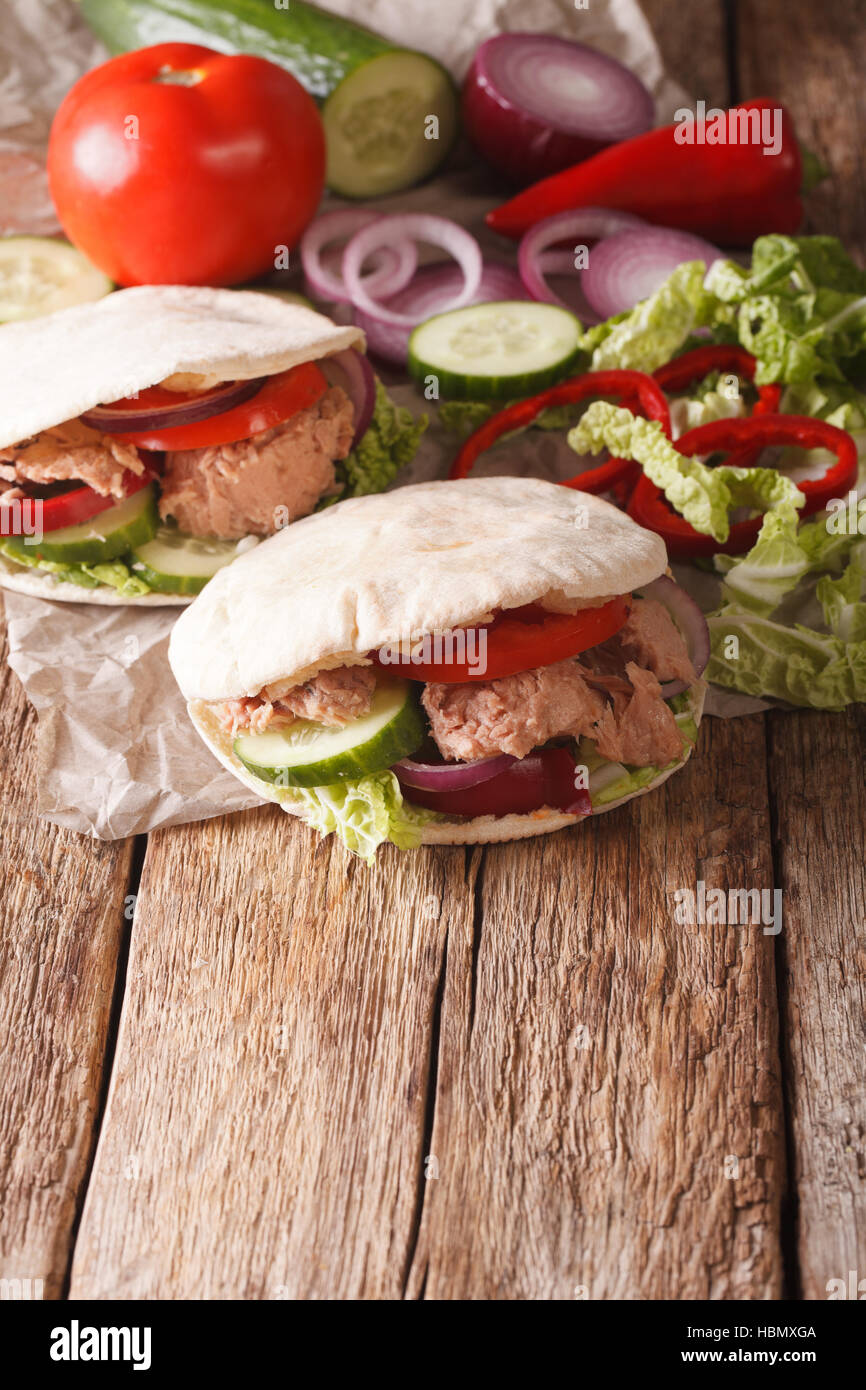Sandwich sano: pita con tonno, cetriolo, cavolo nappa, cipolle, peperoni e pomodori vicino sul piano verticale. Foto Stock