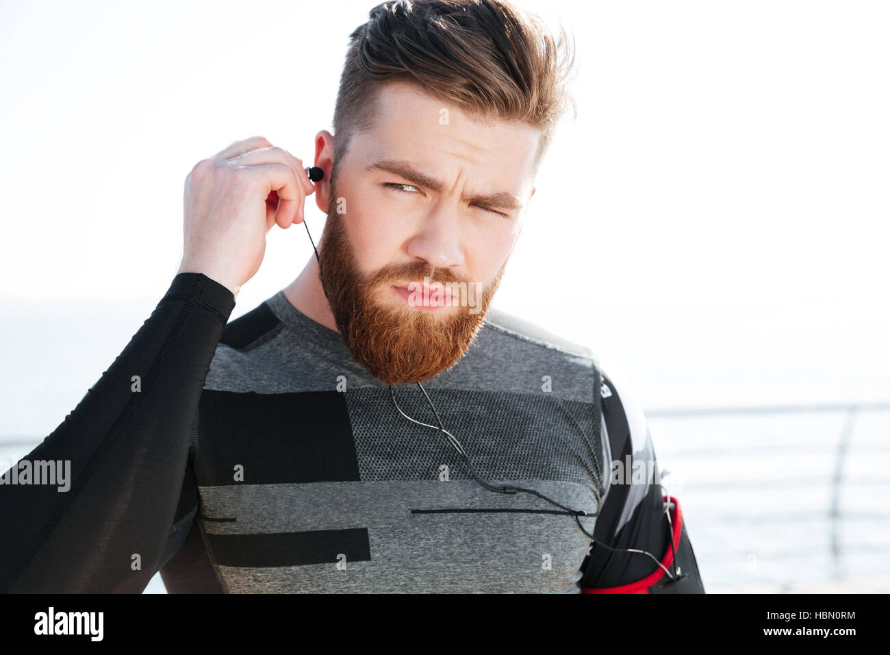 Chiudere i giovani runner in auricolari vicino al mare Foto Stock