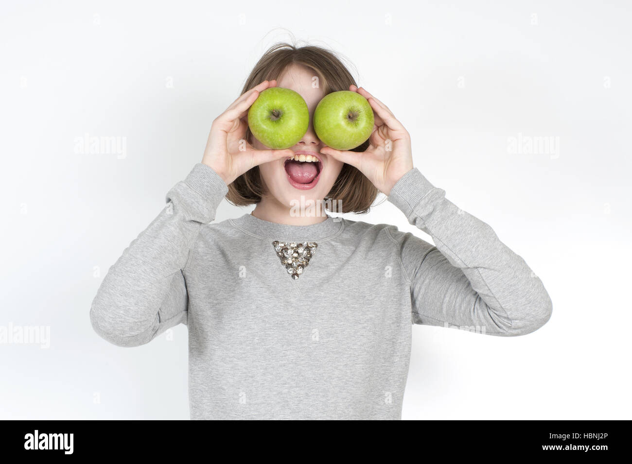 Bambina con due mele verdi. Foto Stock