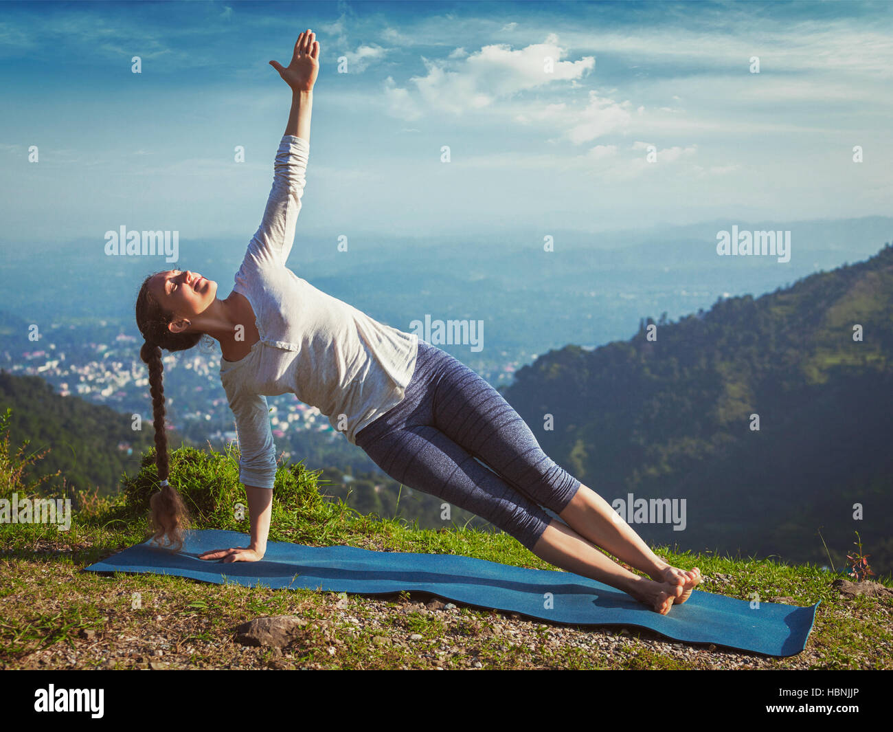 Donna fare yoga asana Vasisthasana - lato plank pongono all'aperto Foto Stock