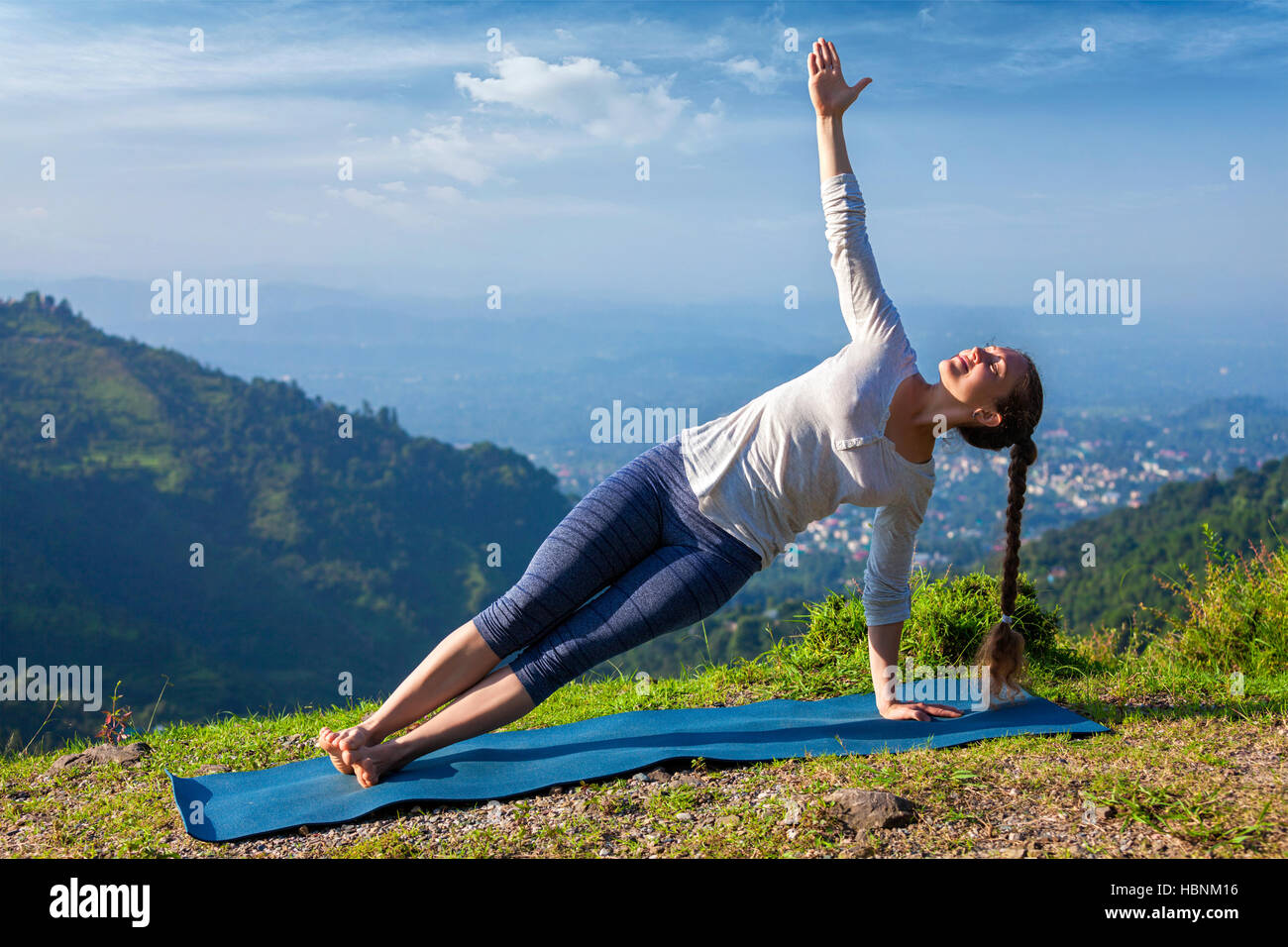 Donna fare yoga asana Vasisthasana - lato plank pongono all'aperto Foto Stock
