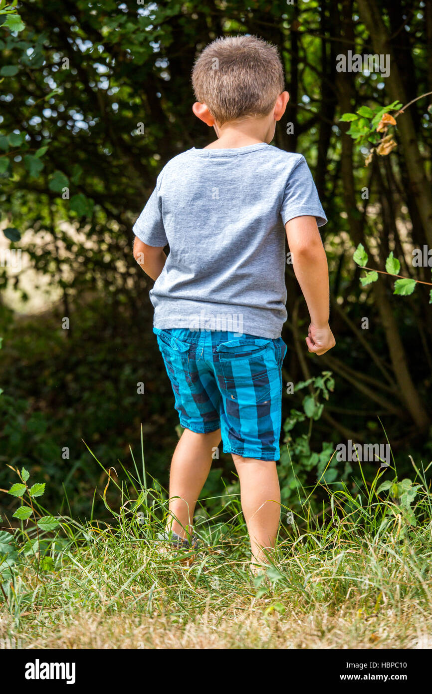 Bambino esplorando la natura al confine con la foresta Foto Stock
