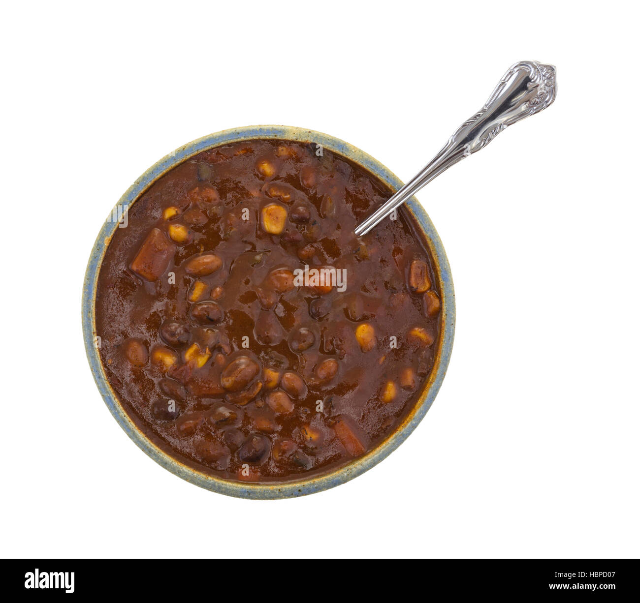 Vista dall'alto di una tazza di verdura tre chili di fagioli con un cucchiaio inserita nel cibo isolato su uno sfondo bianco. Foto Stock