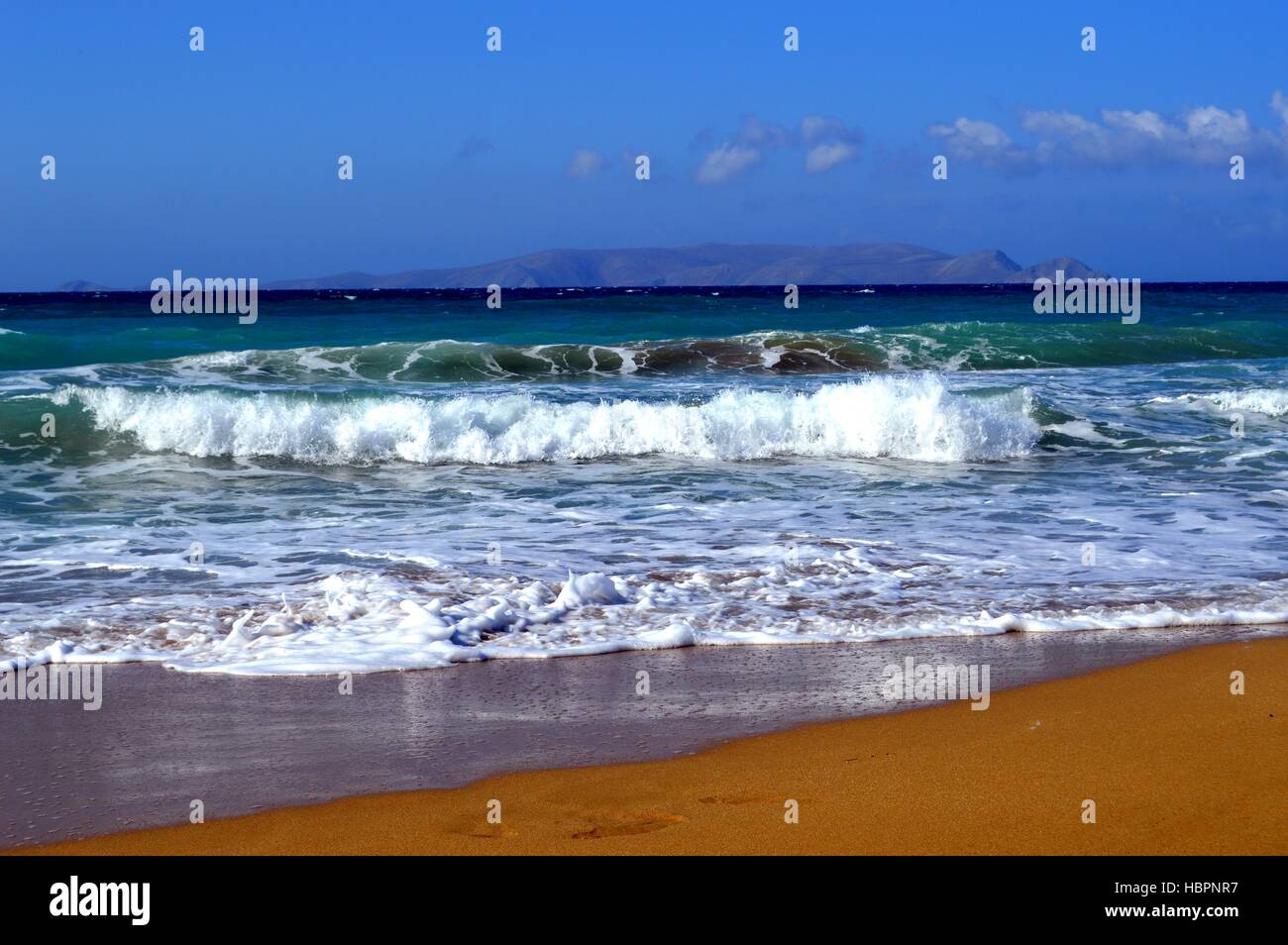 Una spiaggia di sabbia fine con una collina Foto Stock