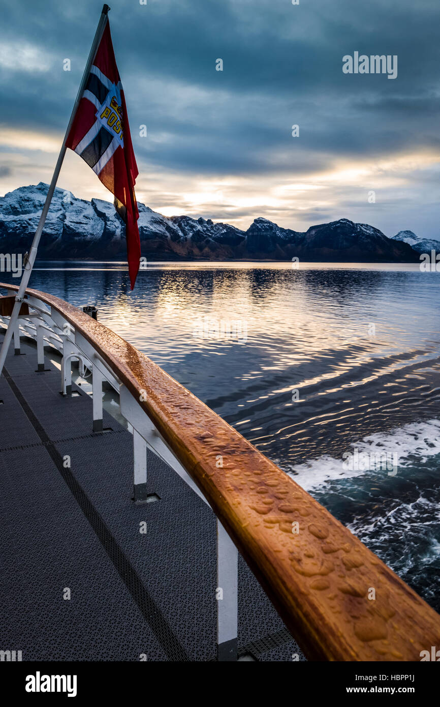 Norwegian bandiera nazionale con inserto Post battenti dalla poppa di Hurtigruten MS Polarlys, Norvegia. Foto Stock