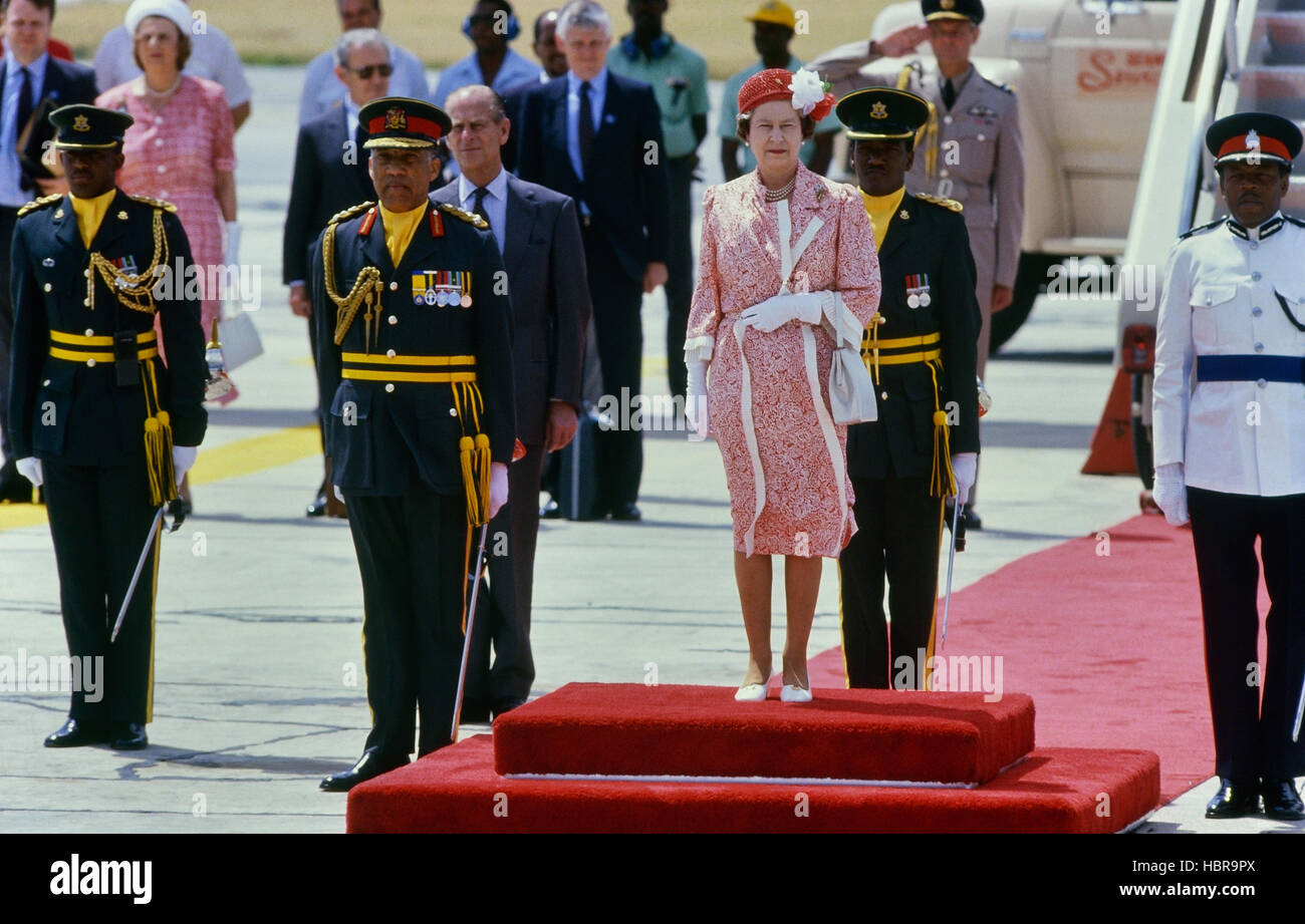 Regina Elisabetta II in piedi sul tappeto rosso con una festa di dignitari prima della sua partenza all'aeroporto internazionale Grantley Adams, Barbados Foto Stock