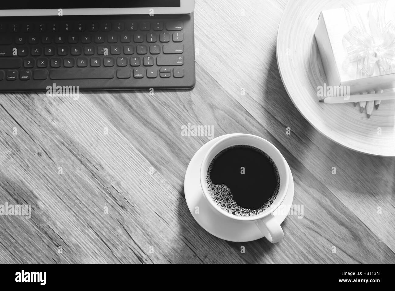 Tazza di caffè e il tavolo digitale dock tastiera intelligente,gold confezione regalo e legno tondo vassoio,matita colorata sul tavolo di legno,l'effetto filtro Foto Stock