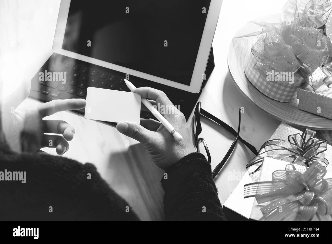 Dare Del Regalo mano creatrice la scelta e la mano con un regalo. Consegna regalo, sorpresa,computer tablet docking tastiera intelligente smart phone sul banco in marmo,nero Foto Stock