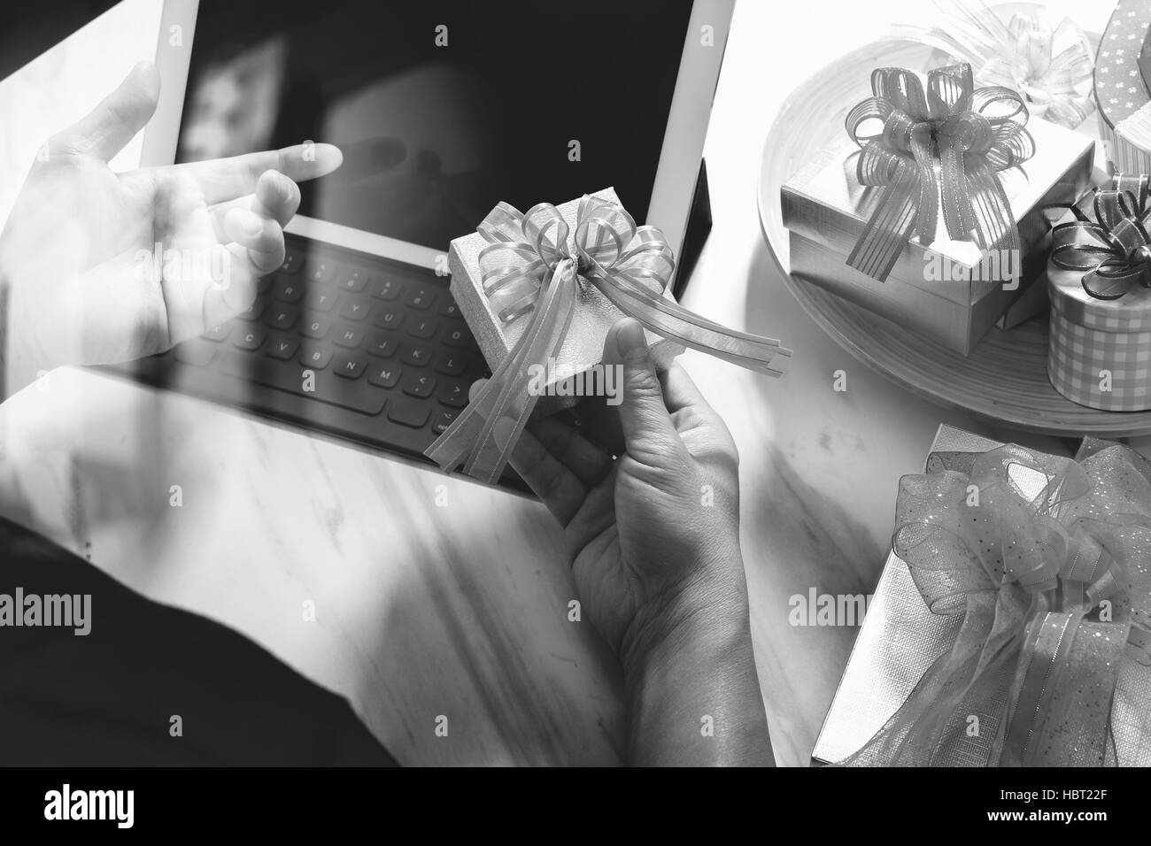 Dare Del Regalo mano creatrice la scelta e la mano con un regalo. Consegna regalo, sorpresa,computer tablet docking tastiera intelligente smart phone sul banco in marmo,vintag Foto Stock