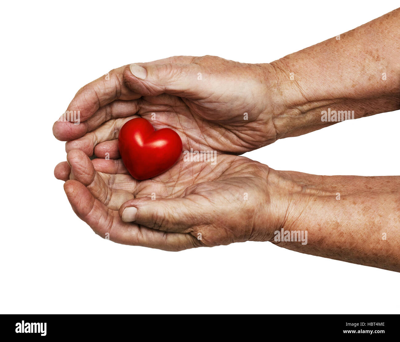 Donna anziana mantenendo il cuore rosso nel suo palms isolati su sfondo bianco, simbolo di attenzione e di amore Foto Stock