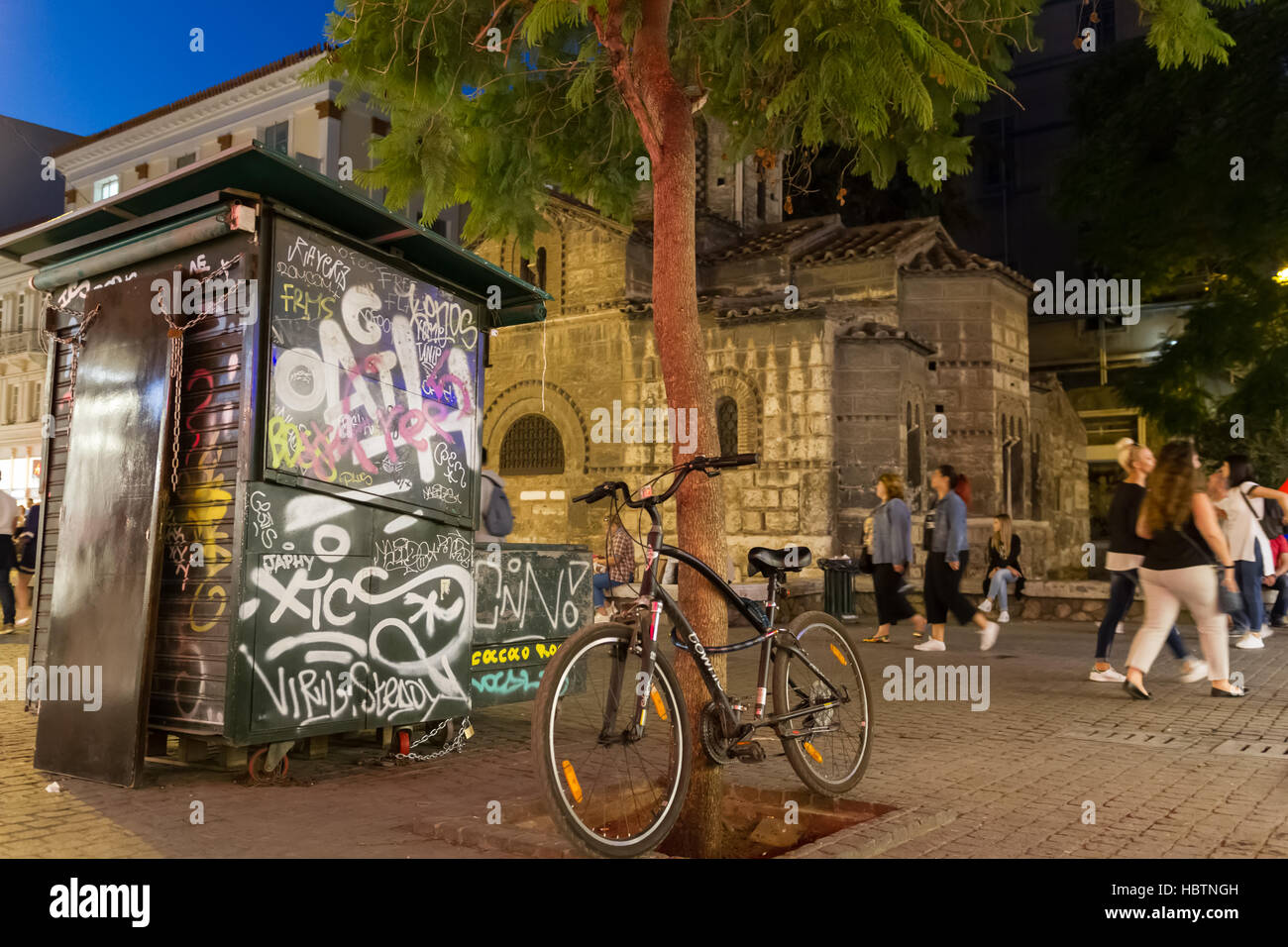 Athens, Grecia - 29 Settembre 2016: Biciclette parcheggiate, graffiti e persone di passaggio dalla chiesa di Panagia Kapnikarea, antica chiesa ad Atene Foto Stock