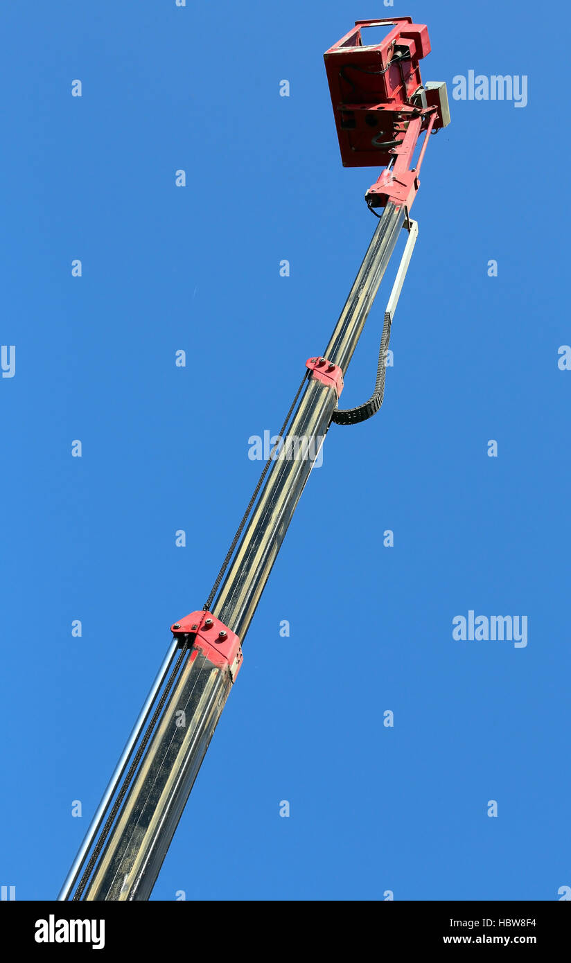 Braccio idraulico in metallo con il cestello di una piattaforma aerea per la massima estensione Foto Stock