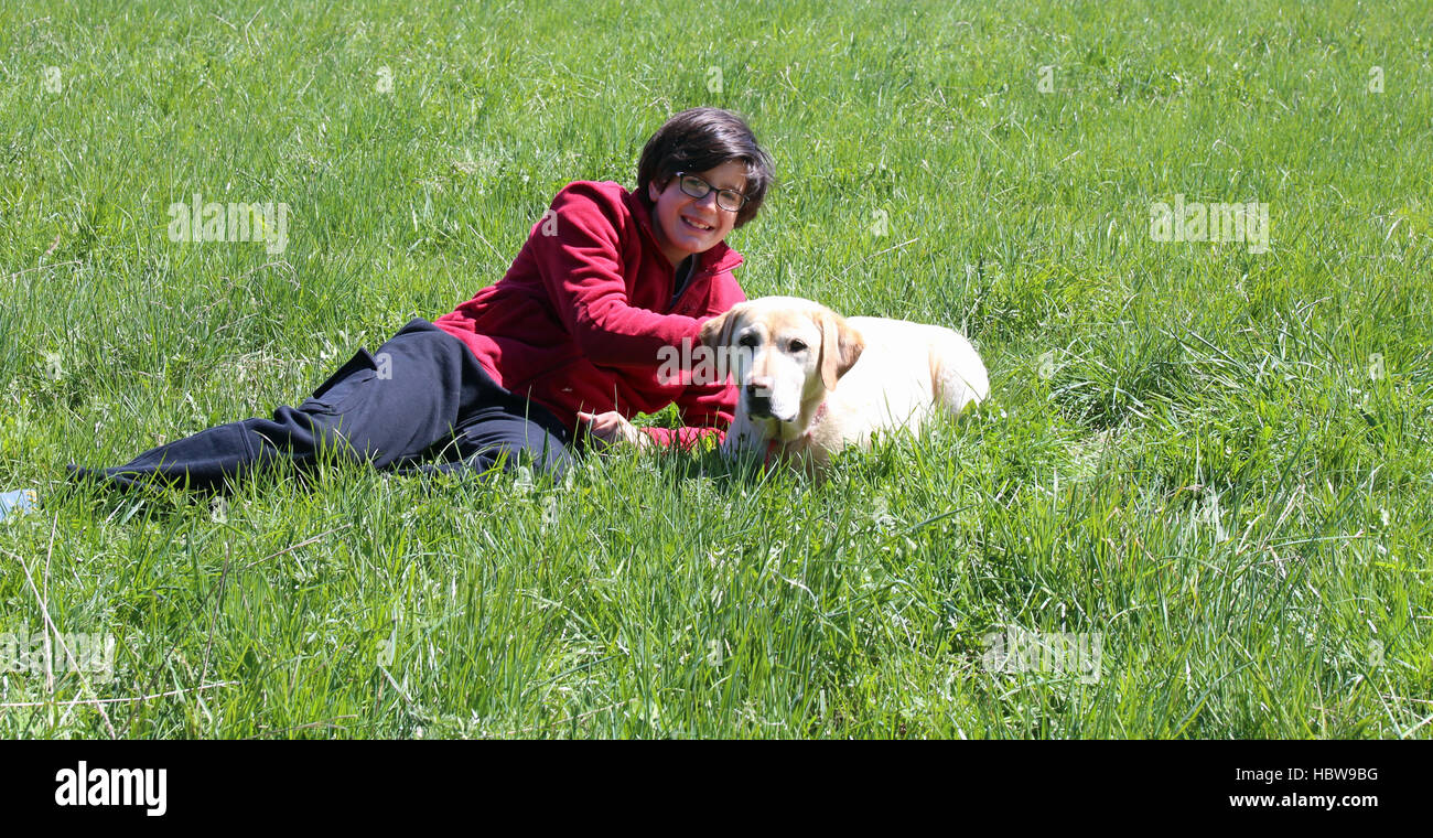 Ragazzo con lunghi capelli neri insieme con il suo cane Labrador Retriever Foto Stock