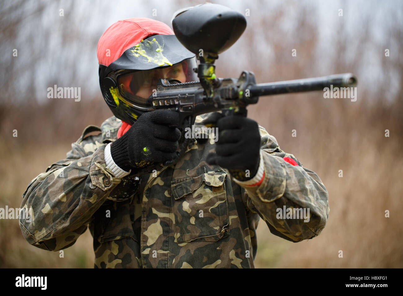 Paintball giocatore indossa la maschera protettiva e la pistola di puntamento Foto Stock