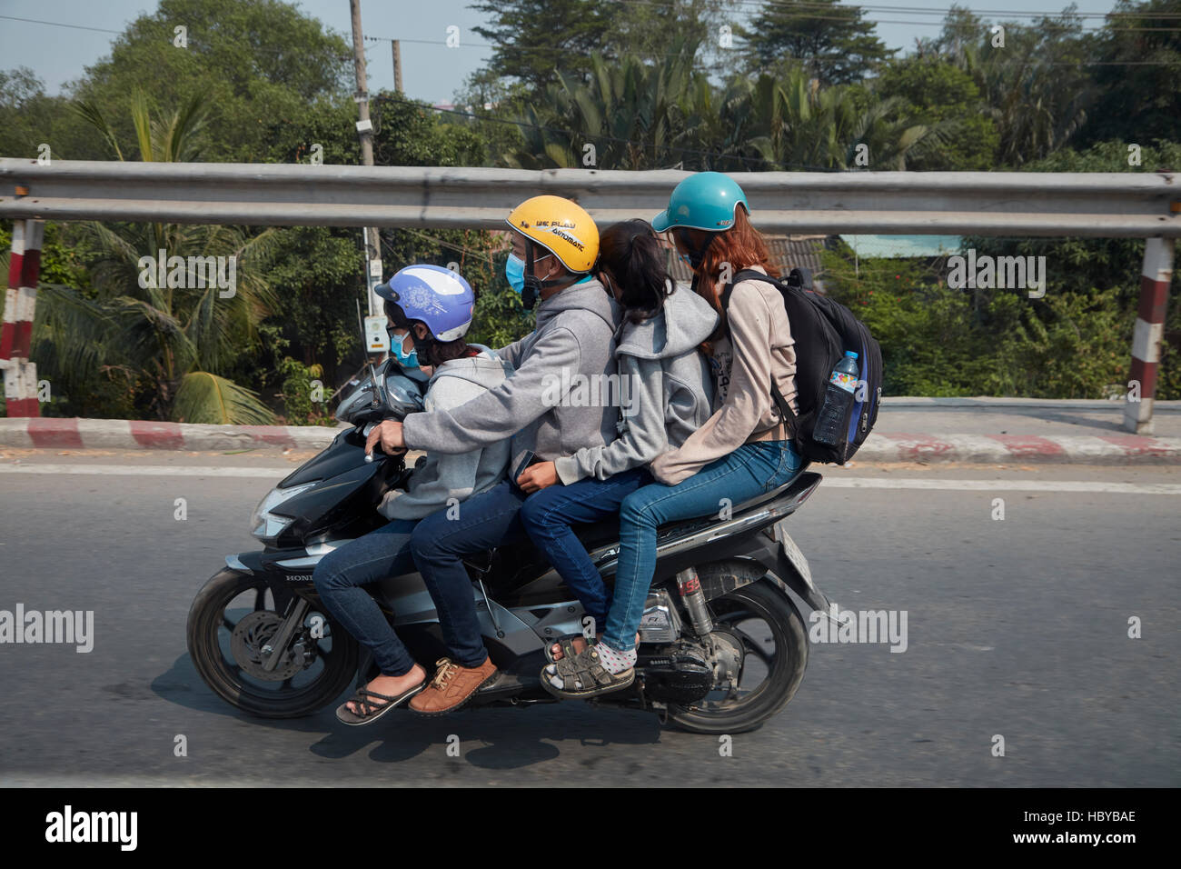 Familiy di quattro sul sovraccarico scooter, Città di Ho Chi Minh (Saigon), Vietnam Foto Stock