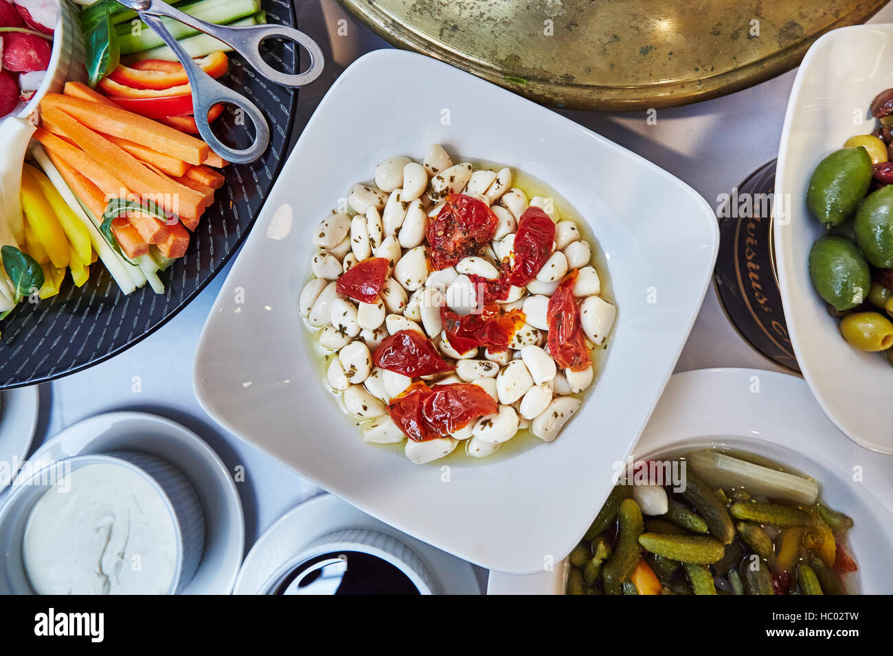 Brunch italiano, selezione di antipasti dal buffet come verdure tagliate, aglio, olive, sottaceti e salse Foto Stock