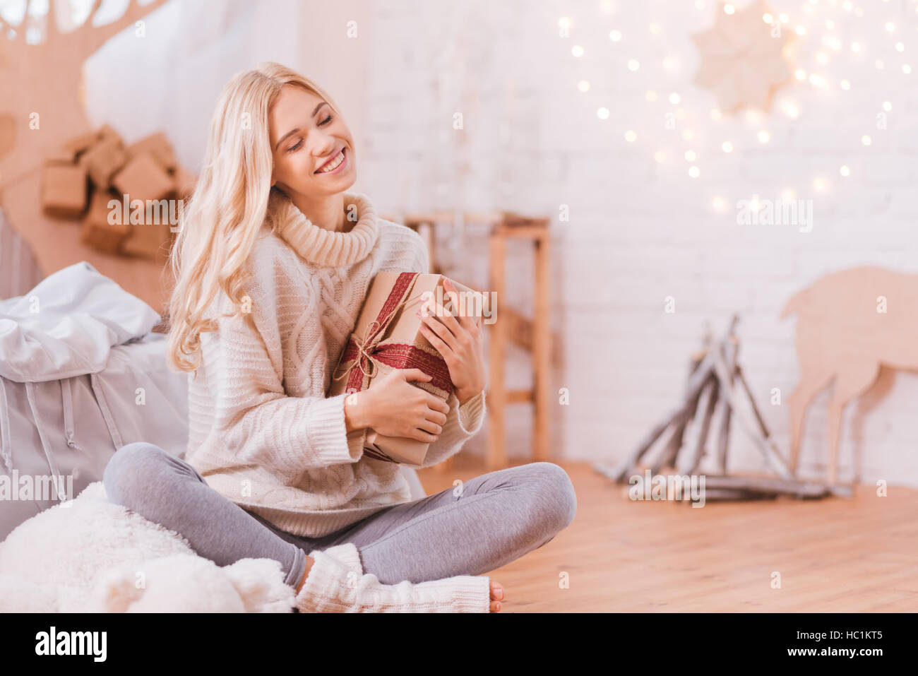 Giovane donna sognante avente una scatola di Natale nelle sue mani Foto Stock