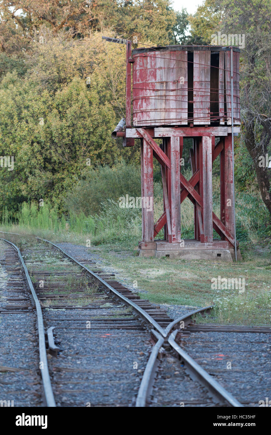 Legno vecchio serbatoio di acqua e i binari della ferrovia, Willits, California. Foto Stock