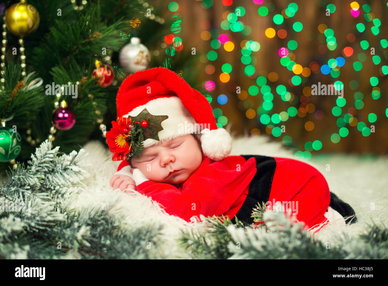 Foto Di Natale Neonati.Ritratto Di Neonato In Santa Vestiti Sdraiati Sotto L Albero Di Natale Foto Stock Alamy