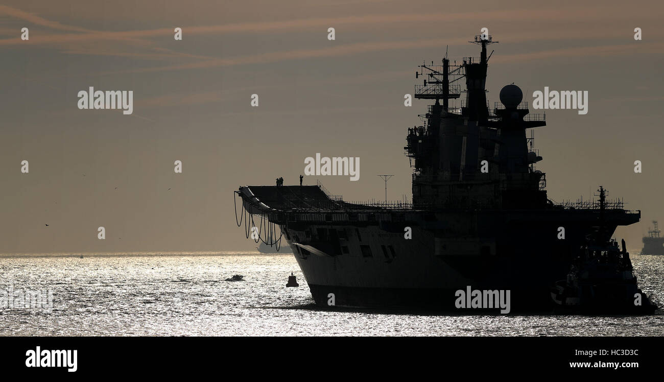 La Royal Navy dell ex portaerei HMS illustre è trainato fuori del porto di Portsmouth voce per un bagno turco scrapyard. Foto Stock