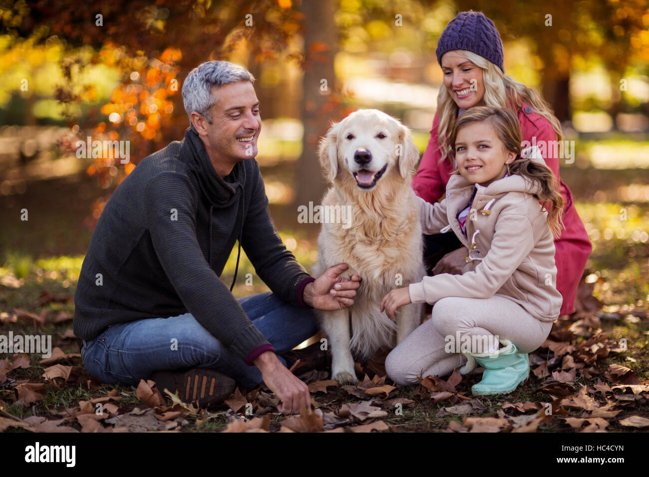 Seduta di famiglia con il cane in posizione di parcheggio Foto Stock