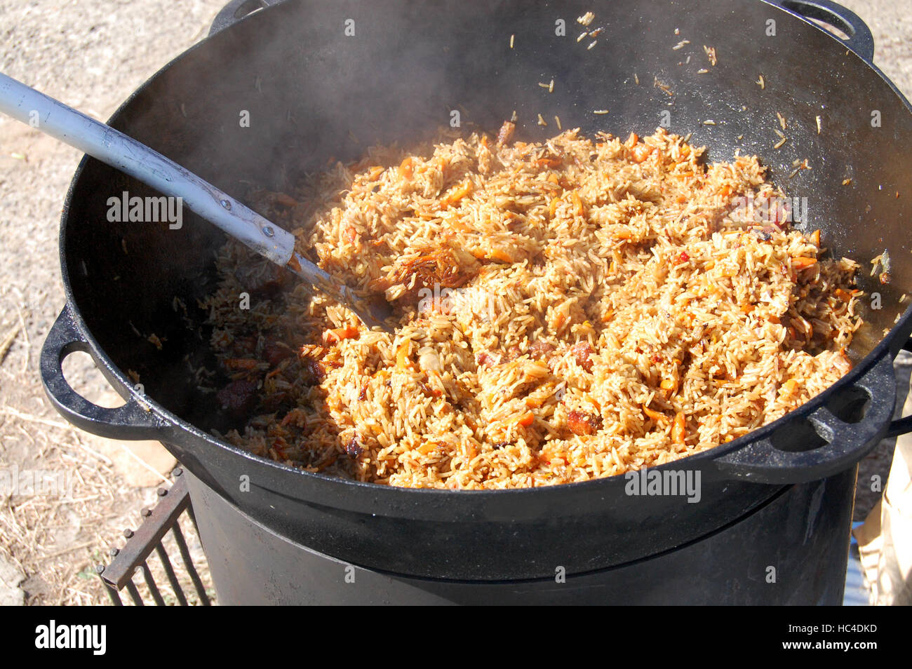 La cottura pilaf piatto in outdoor. pilaf in un calderone, cibo di strada Foto Stock