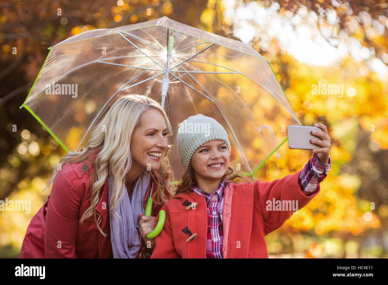 Ragazza tenendo selfie con la madre in posizione di parcheggio Foto Stock