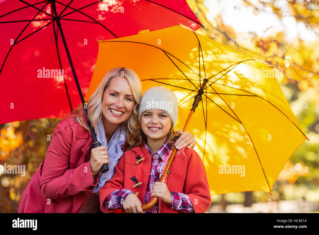 Ragazza con ombrello con la madre in posizione di parcheggio Foto Stock