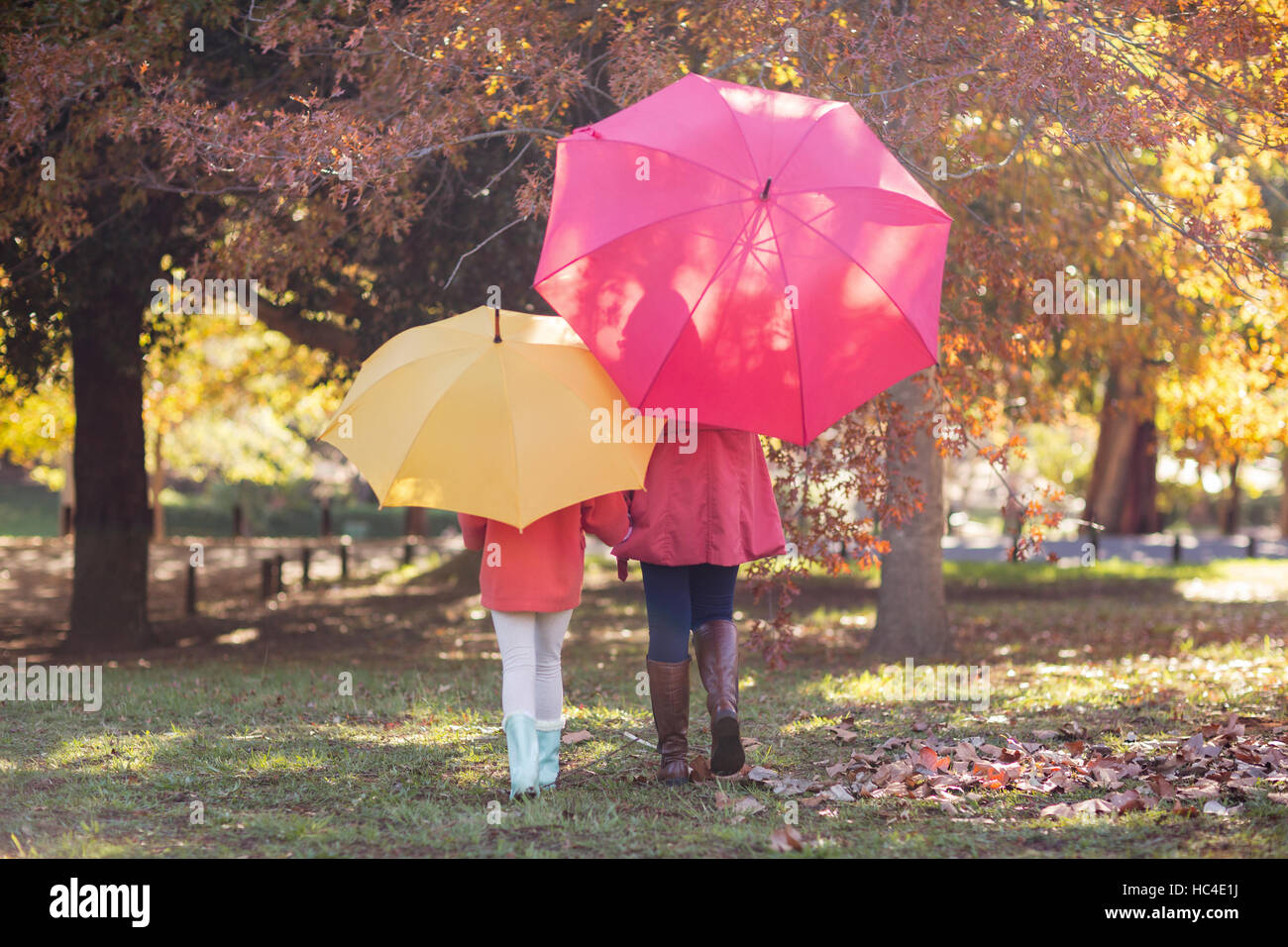 Madre e figlia con ombrellone al park Foto Stock