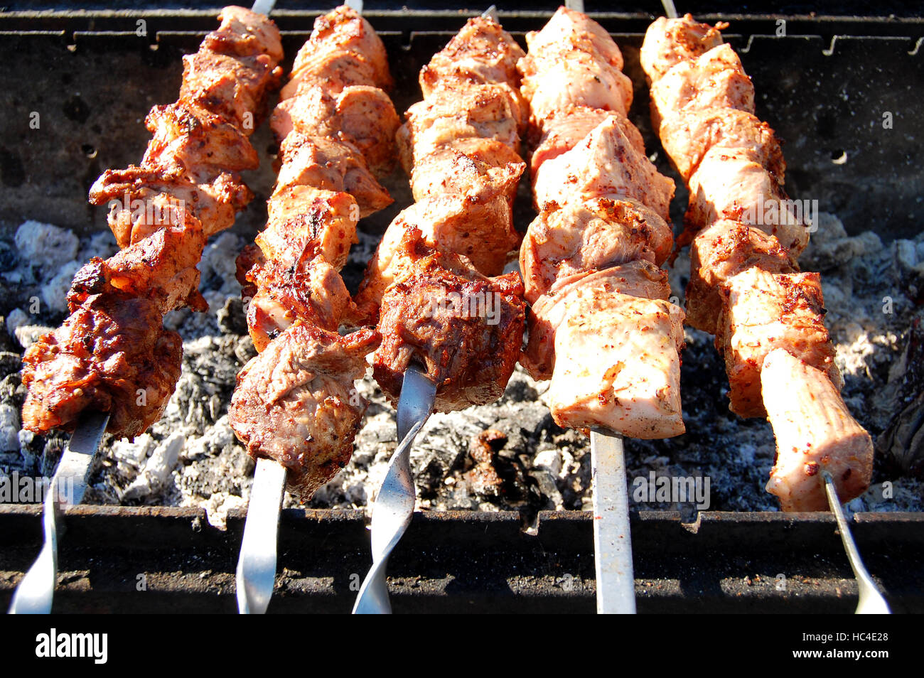 Grigliata di shish kebab su spiedino di metallo, primo piano. Arrosti di carni cotte al barbecue. Barbecue di carne bovina fresca tritate Fette. Tradizionale piatto orientale. Grill a carbone Foto Stock
