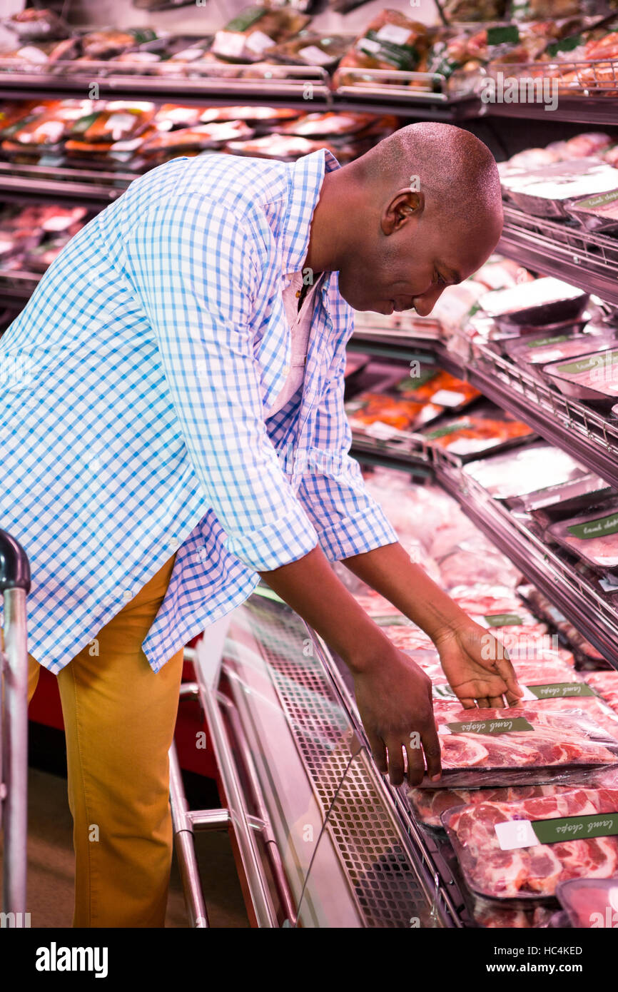 Uomo che guarda merci nella sezione di generi alimentari mentre lo shopping Foto Stock
