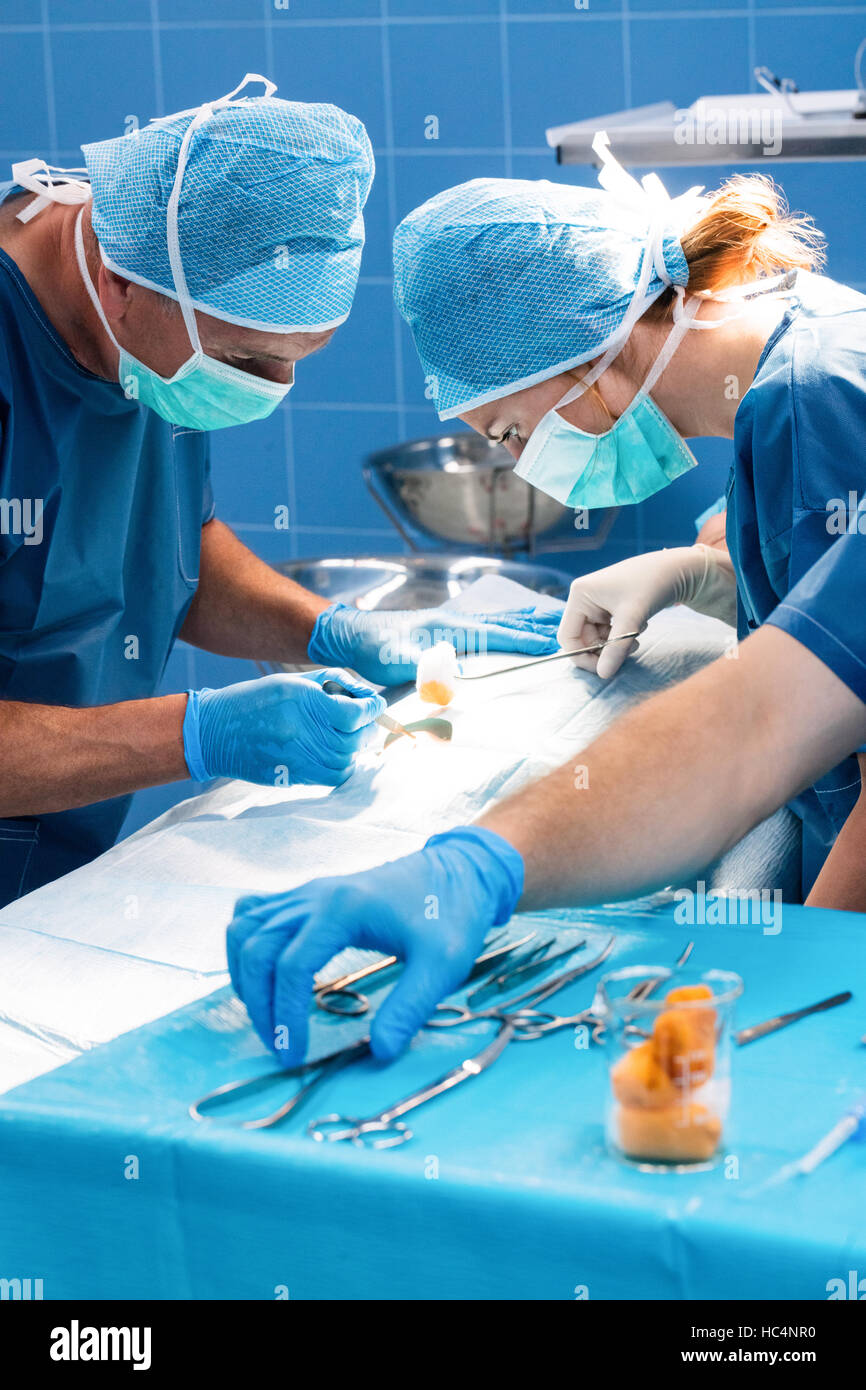 Il team di chirurgia il funzionamento di un paziente in sala operatoria Foto Stock