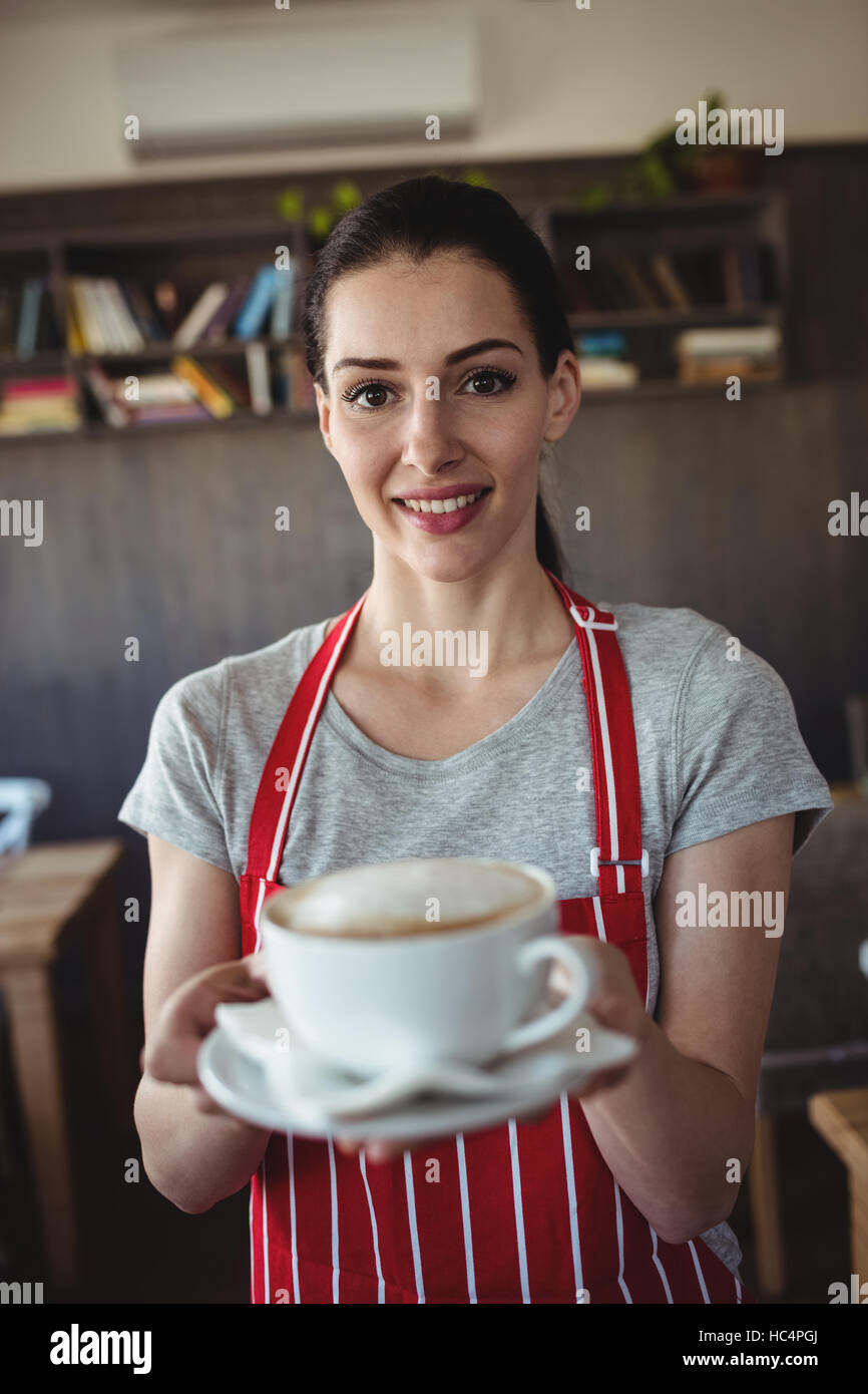 Il panettiere femmina tenendo una tazza di caffè Foto Stock