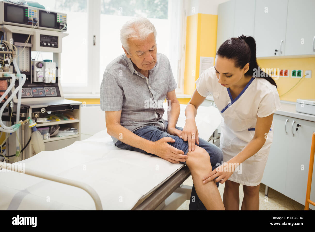 Medico donna esaminare pazienti ginocchio Foto Stock
