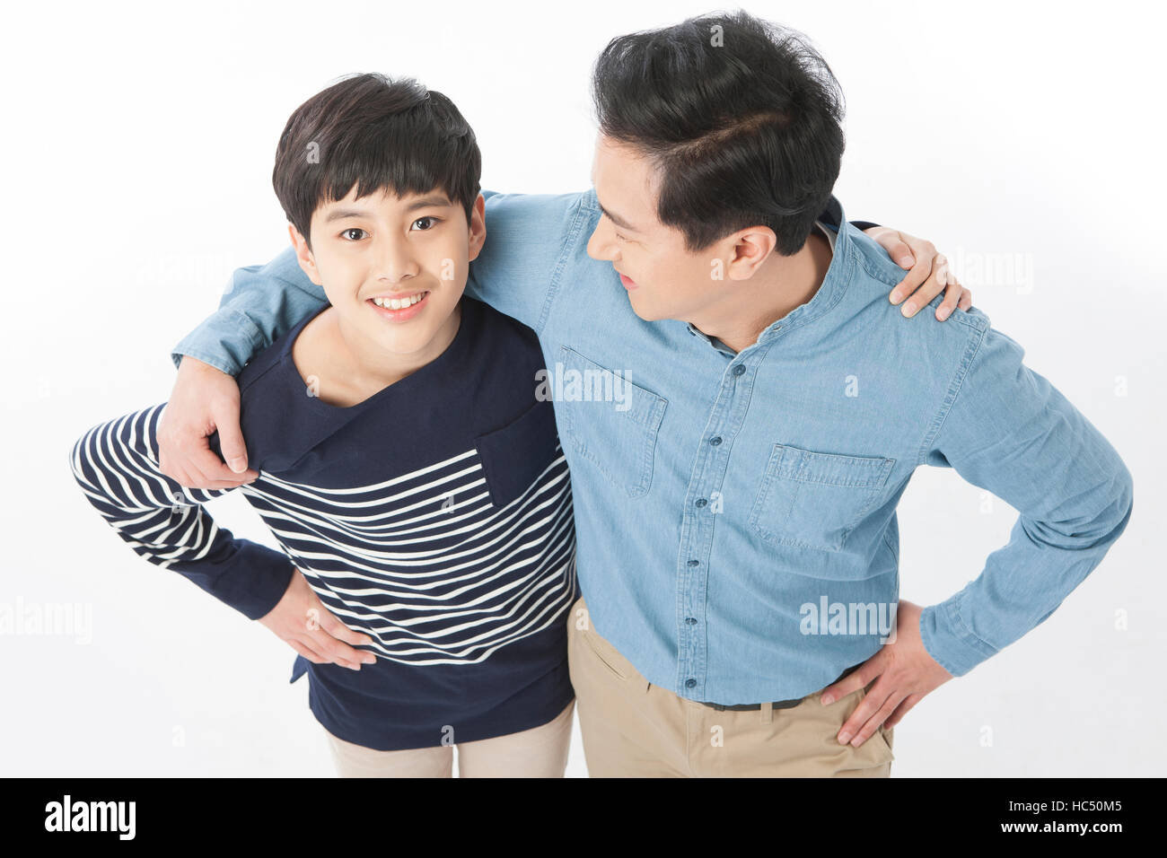 Angolo di alta vista sorridente medio di età compresa tra padre e figlio adolescente di mettere le mani su ogni altro spalle Foto Stock
