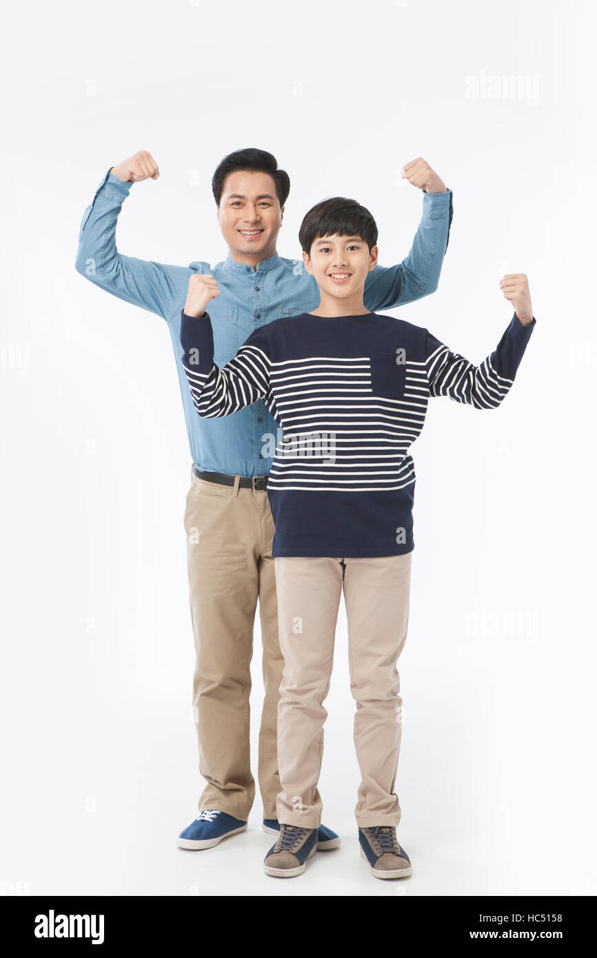 Sorridente di mezza età e padre sorridente figlio adolescente in piedi sollevando i loro pugni Foto Stock