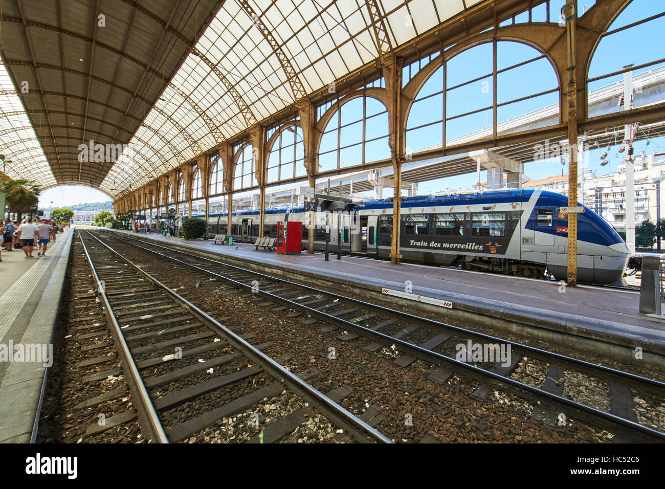 Panorama della stazione ferroviaria nel centro, giornata di sole e cielo blu, un sacco di turisti, rotaie sotto vetro Un tetto Foto Stock