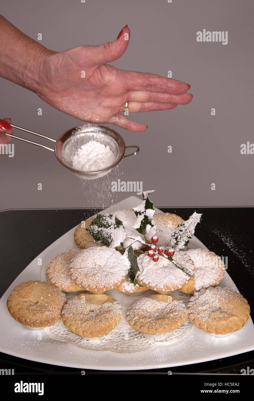Tritare tradizionali torte con un rivestimento di zucchero a velo e un rametto di agrifoglio Foto Stock