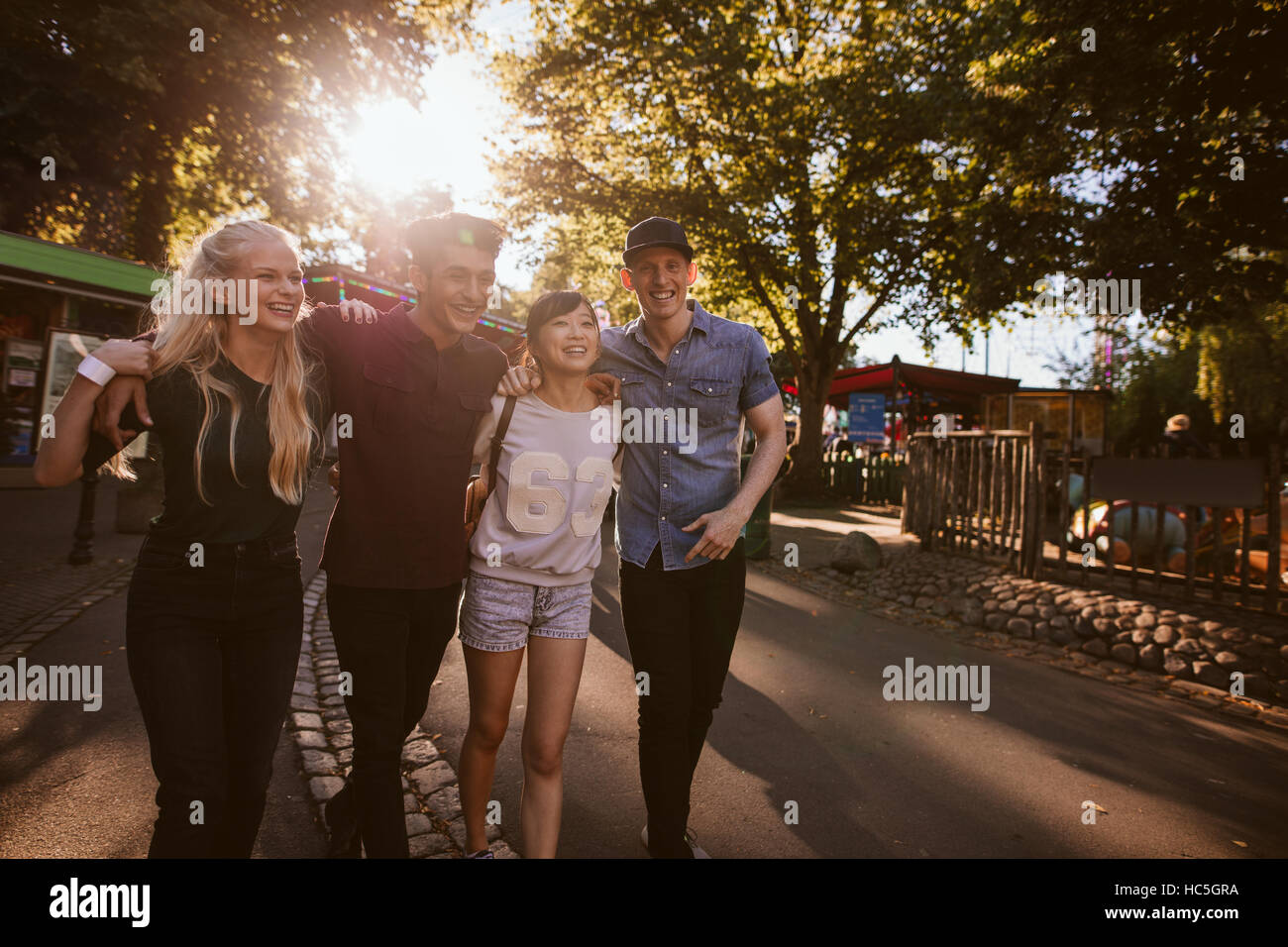 Un gruppo di amici migliori appendere fuori insieme e a piedi attraverso un parco. Tutti gli amici avente un tempo buono e sorridente. Foto Stock